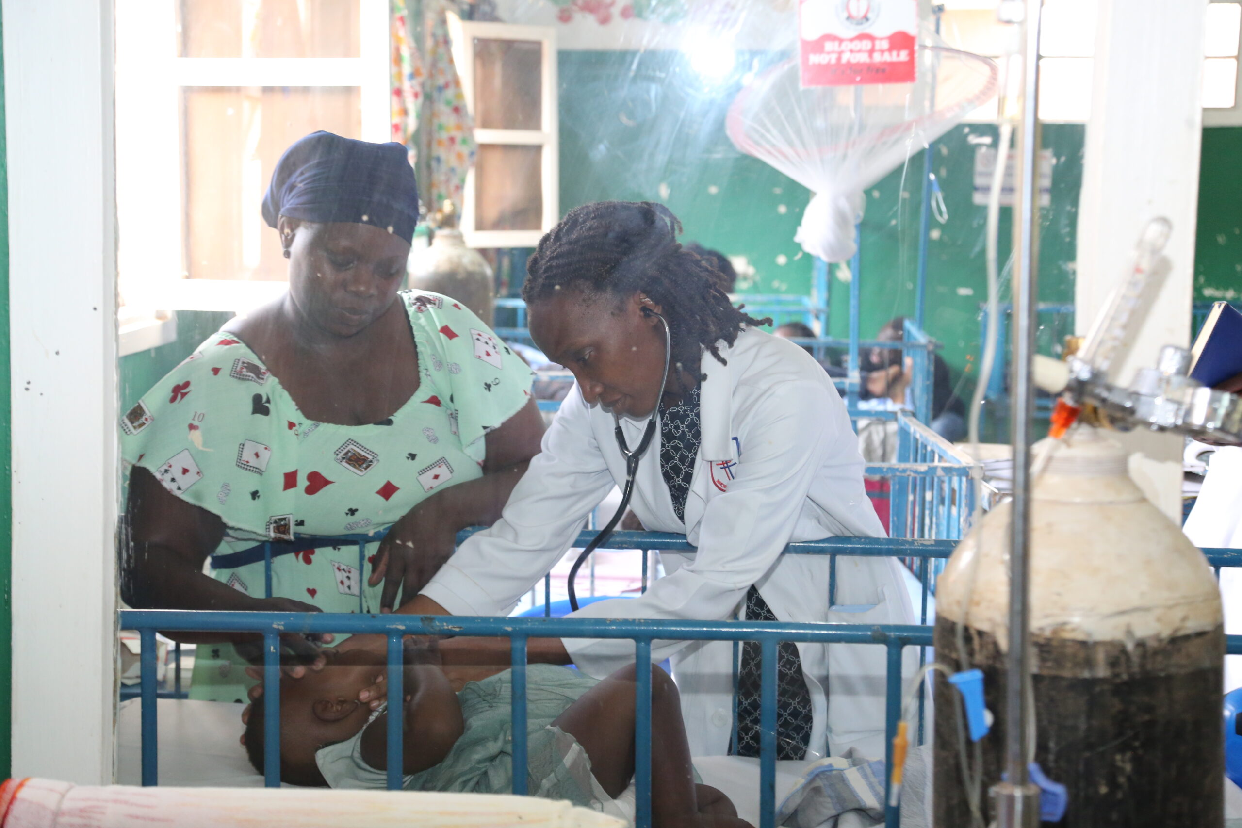 Dr. Rhoda attends to a patient as the mother looks on.