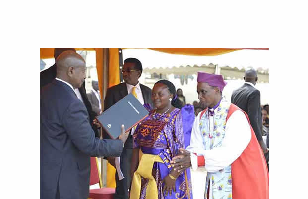 Bishop Zoreka and his wife handing over a bible to President Museveni