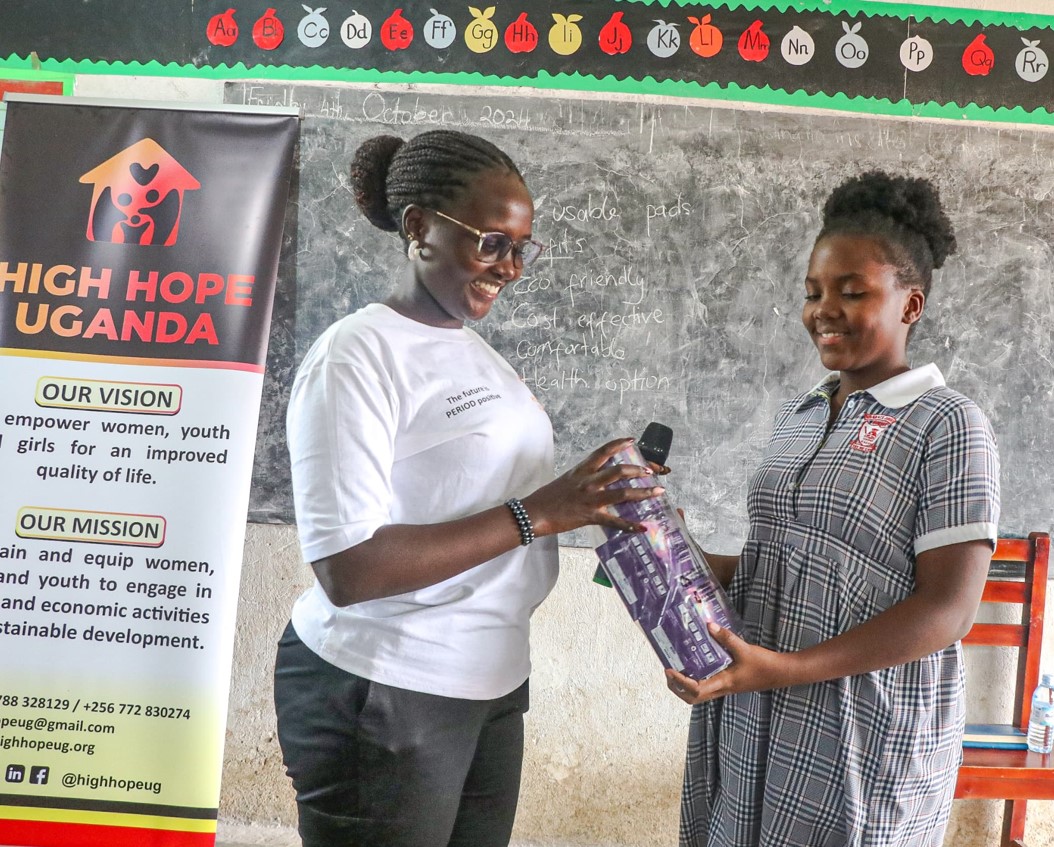Kusiima awarding a girl goodies during one of the outreaches for her organization, High Hope Uganda.
