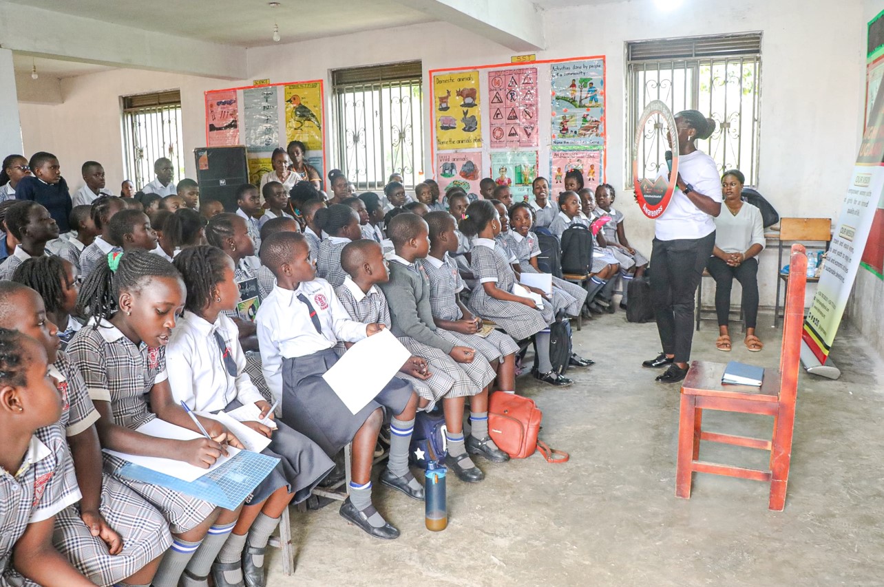 School children listening attentively during a presentation by Kusiima