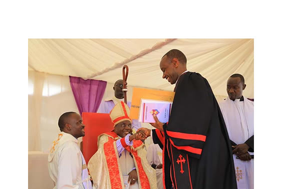 Assoc. Prof. Aaron Mushengyezi receiving church instruments of power