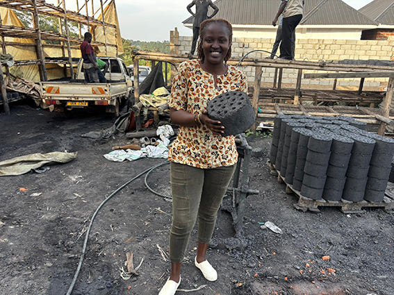 Longora holding briquettes. Her videos show simple ways to protect the environment, like using clean energy