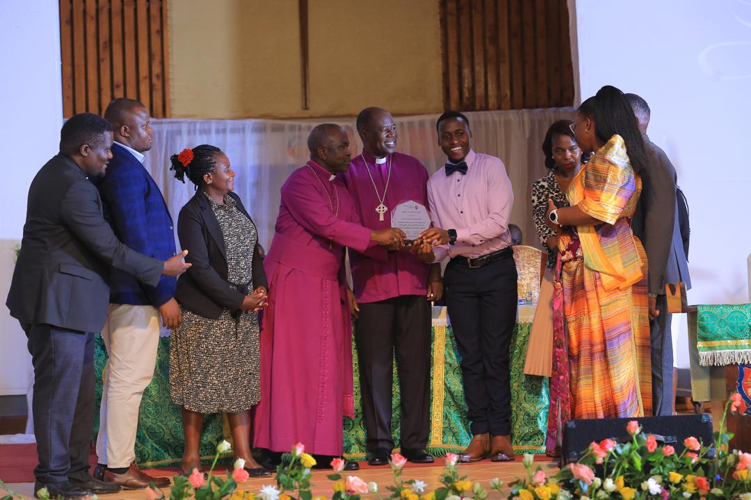 Timothy Kirabo (third right) is with his parents (right, second-right), his friend Sanyu Bridget Kiwala and her parents, and UCU Partners Executive Director, Mark Bartels (center), on graduation day on July 4. Kirabo is a recipient of a partial scholarship from the Partners nonprofit.