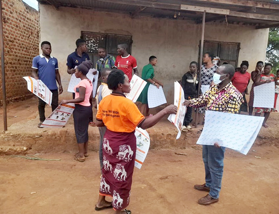 Thembo (right) with Village Health Team coordinators as they prepared to pin up MPOX posters and carry out risk communication