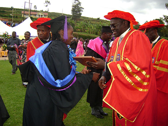 Dianah Aharimpisya receiving a plaque from former Vice Chancellor John Senyonyi after she attained a First Class degree at UCU.