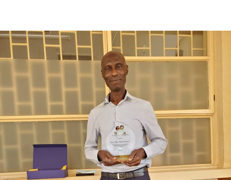 New dean of UCU SoM Assoc. Prof. Charles Karamagi holding an award he got from Makerere University in 2022 for his service in training paediatricians and child health specialists