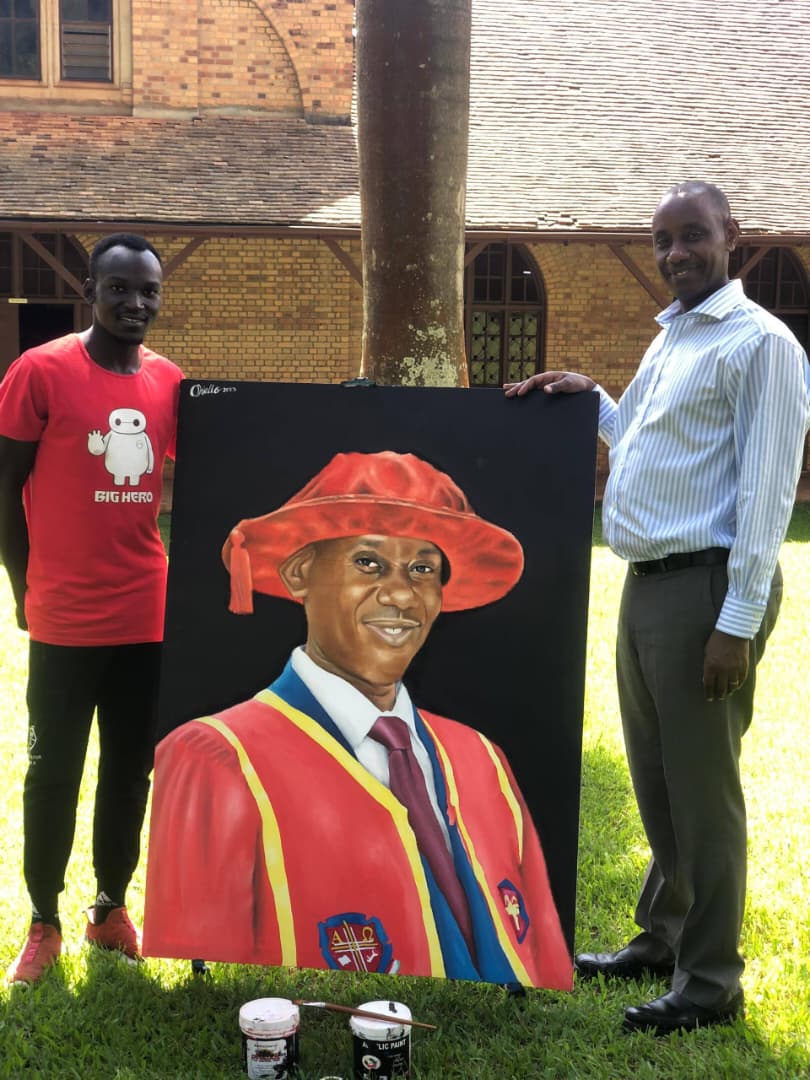 Okello and UCU Vice Chancellor Aaron Mushengyezi with a painting that the artist made