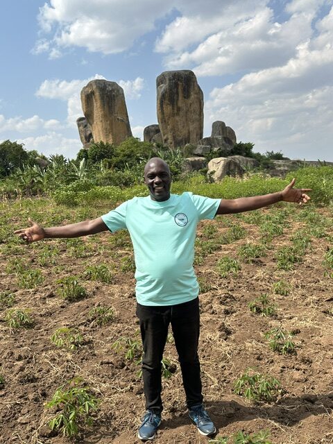 Frank Obonyo poses in front of a formation that locals call “Rock 7” – lesser-known than Tororo Rock, a volcanic formation popular for climbing. The rock behind and rocks around Frank are near where his grandmother was born and are often found with maize and other crops spread about them for drying.