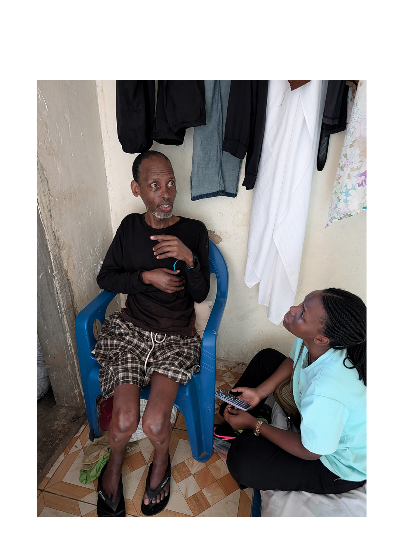 Linda Ojore, Uganda Christian University School of Medicine student, talks to Patrick Byaruhanga, a Kampala resident with a neurological diagnosis of Parkinson’s Disease.