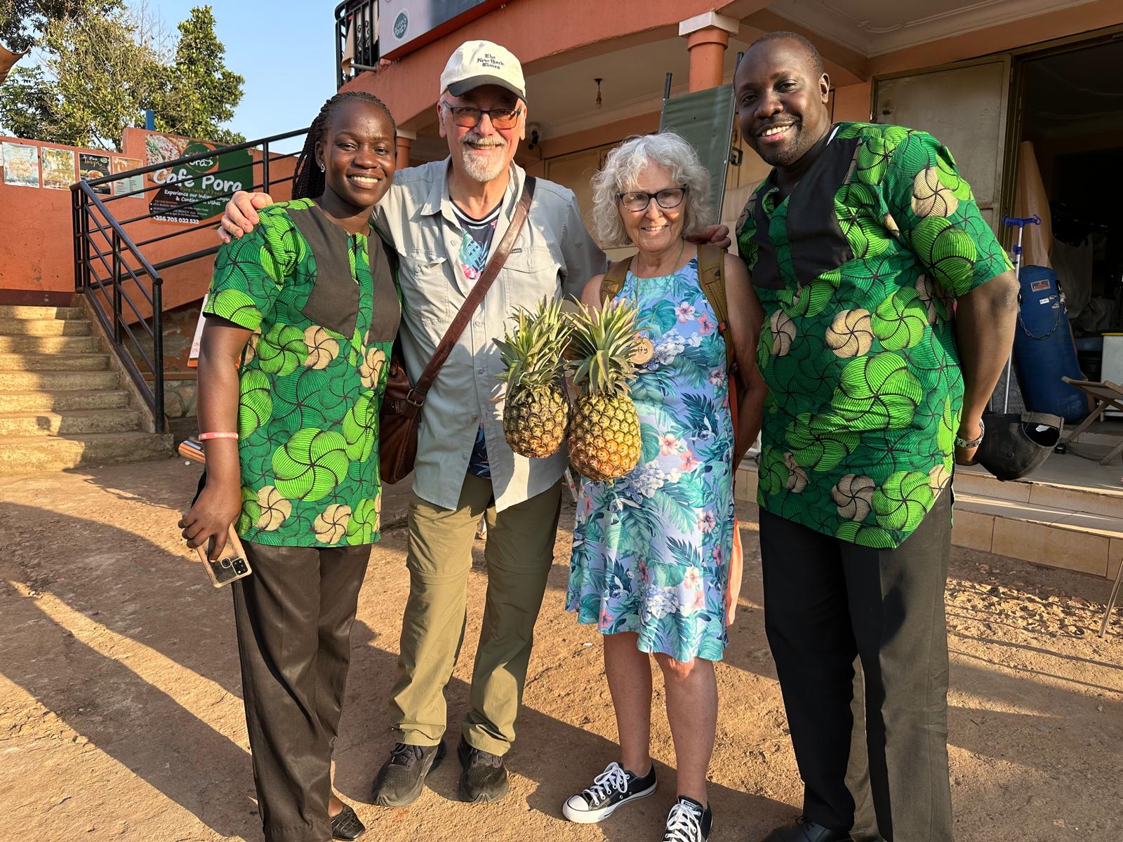 Ugandans Sarah and James Walamaku with Americans Patty Huston-Holm and Mike Holm, holding pineapple purchased in Luwero this summer