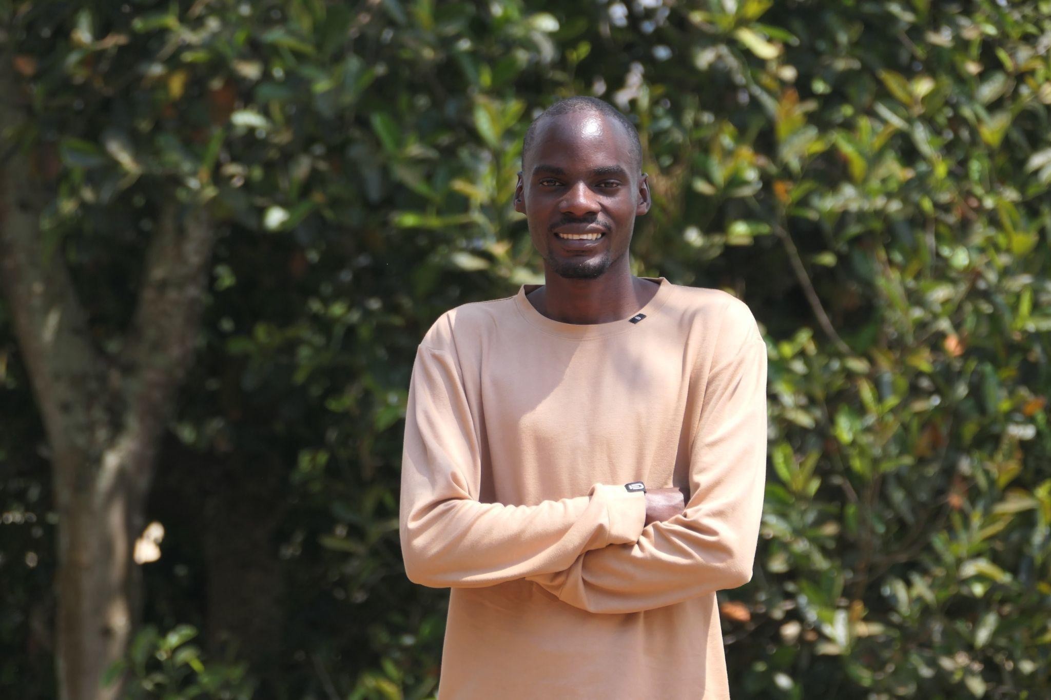Godfrey Mucunguzi, smiling after completing his first degree in Computer Science
