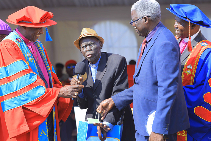 Kasamba after being honored at the 2025 graduation at the UCU main campus. Left is UCU Chancellor Archbishop Stephen Kaziimba and right is the Rt. Rev. Prof. Alfred Olwa, the Chairperson of UCU Governing Council