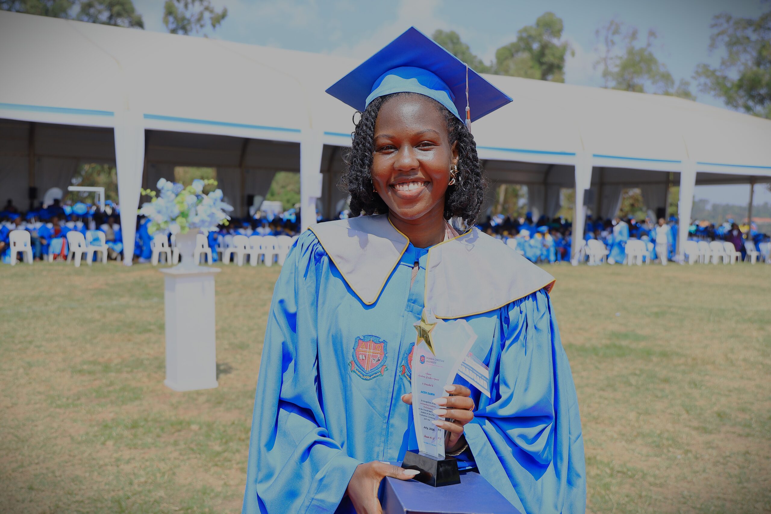 Dawn Acen holds her award after graduating as the overall best student at Uganda Christian University on July 3, 2026. She earned a remarkable 4.91 GPA, the highest among the graduating class